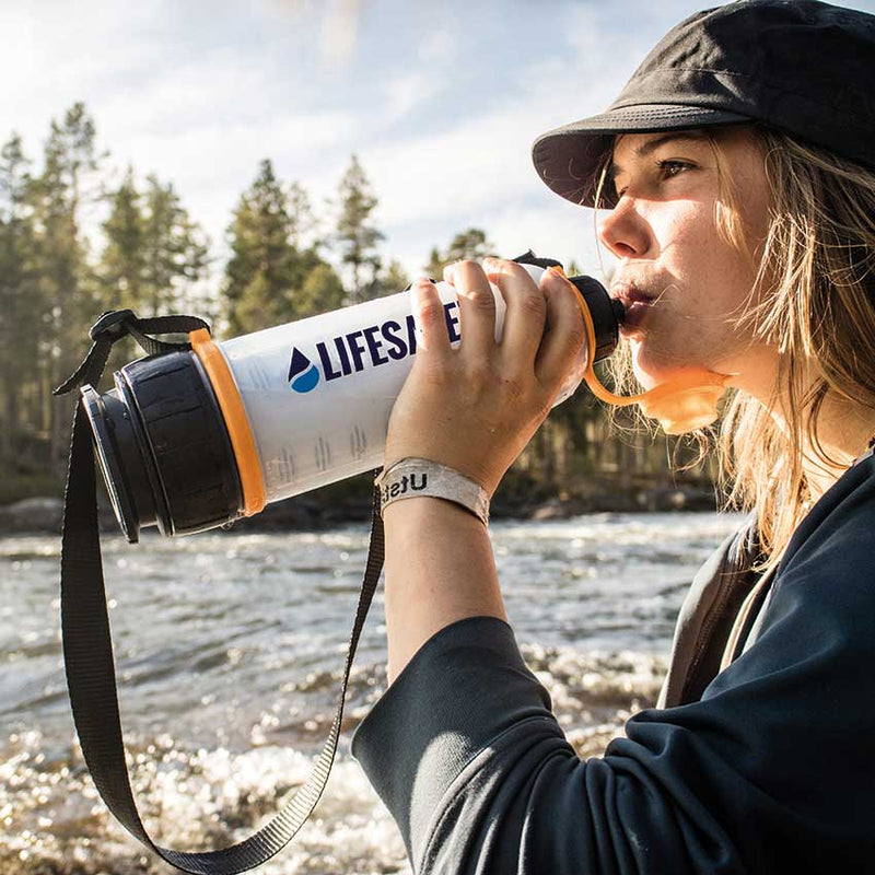 Carregar imagem no visualizador da galeria, Girl drinking from the LifeSaver 4000UF Bottle by a river in Sweden