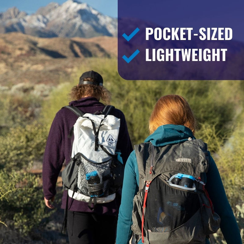 Carregar imagem no visualizador da galeria, Hikers walking towards a mountain with LifeSaver Wayfarer water filters in their backpacks

