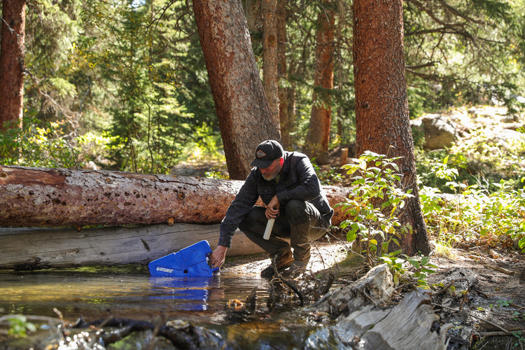 Filling a jerrycan by a river bank