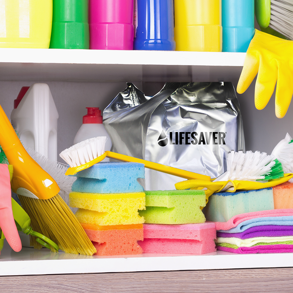 Cleaning supplies including sponges, brushes, and a foil-sealed 'Lifesaver Cube' on a shelf.