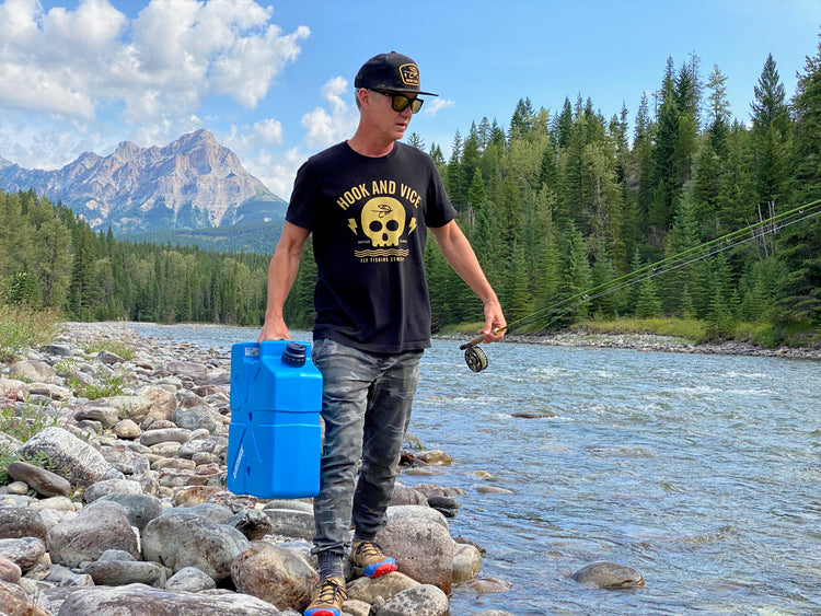 Man with a fishing rod and LifeSaver Jerrycan by a river