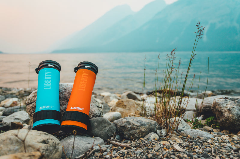 Carregar imagem no visualizador da galeria, Two Liberty water bottle filters by a lake
